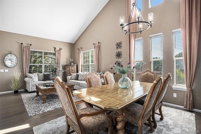 dining area featuring an inviting chandelier, wood finished floors, a healthy amount of sunlight, and high vaulted ceiling