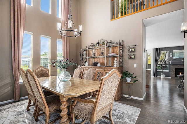 dining space with a notable chandelier, plenty of natural light, wood finished floors, and baseboards