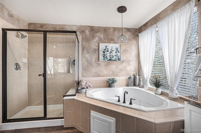 bathroom with a stall shower, wood finished floors, and a whirlpool tub