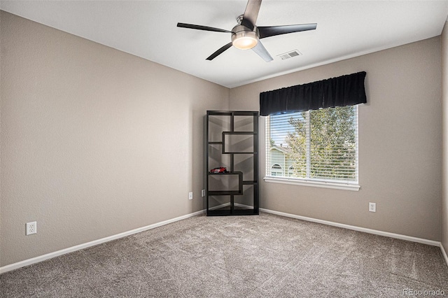 carpeted empty room featuring visible vents, baseboards, and ceiling fan