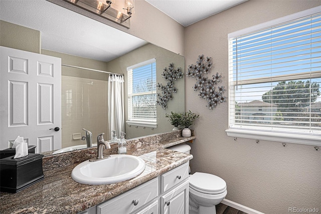 full bath with curtained shower, baseboards, toilet, and vanity