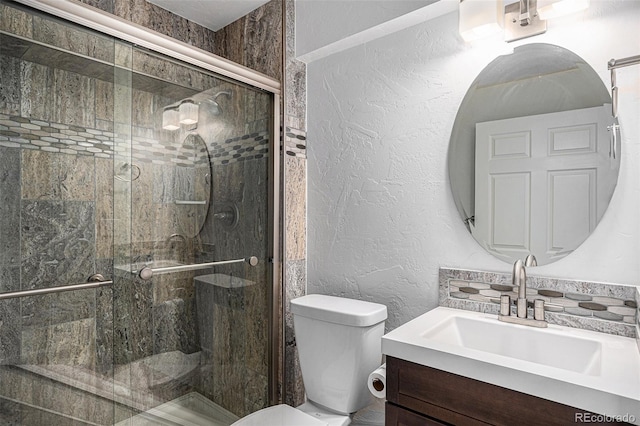 full bath featuring a shower stall, toilet, vanity, and a textured wall