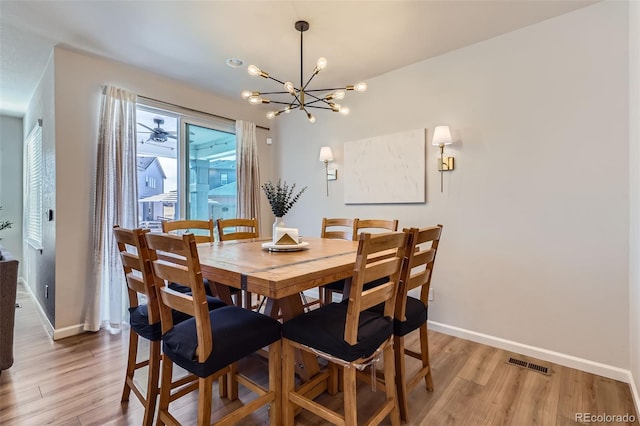 dining space featuring baseboards, visible vents, a chandelier, and light wood-type flooring