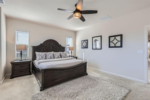 bedroom featuring visible vents, light carpet, baseboards, and ceiling fan