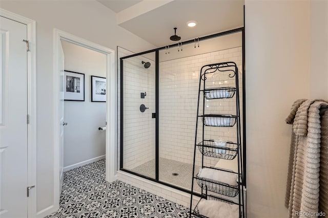 bathroom featuring tile patterned flooring, baseboards, and a stall shower