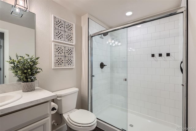 full bath with vanity, toilet, and a shower stall