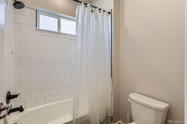 bathroom featuring shower / bathtub combination with curtain and toilet