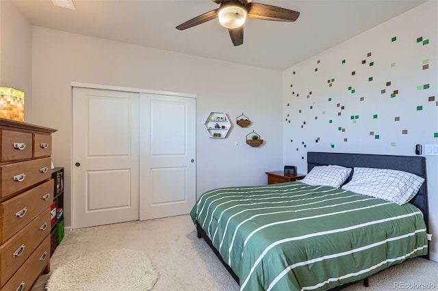 bedroom with a closet, light carpet, and a ceiling fan