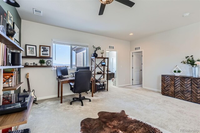 carpeted office space featuring visible vents, baseboards, and ceiling fan