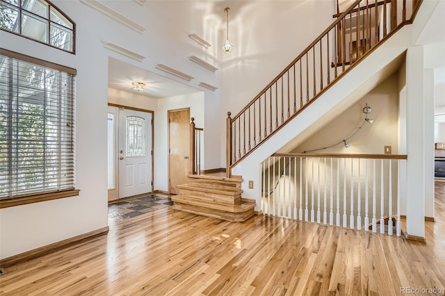 foyer with light hardwood / wood-style floors and a high ceiling