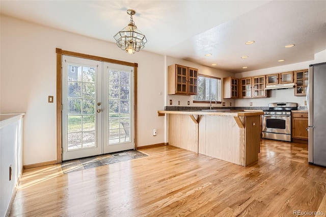 kitchen with a healthy amount of sunlight, stainless steel appliances, a breakfast bar area, and kitchen peninsula