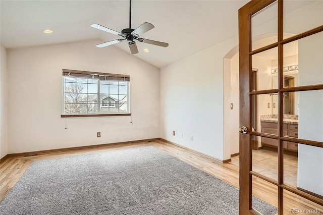 spare room featuring hardwood / wood-style floors, vaulted ceiling, and ceiling fan