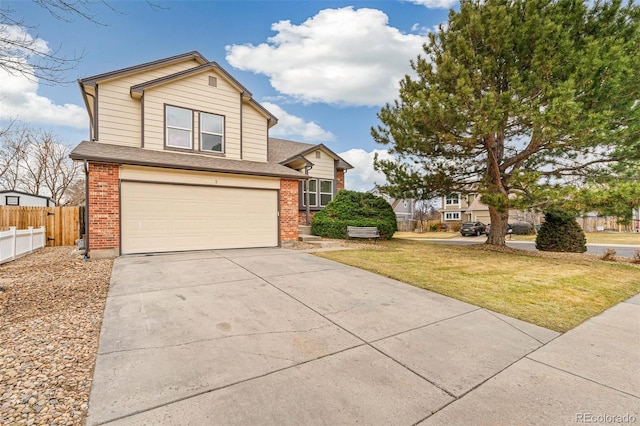 traditional home featuring brick siding, an attached garage, a front yard, fence, and driveway