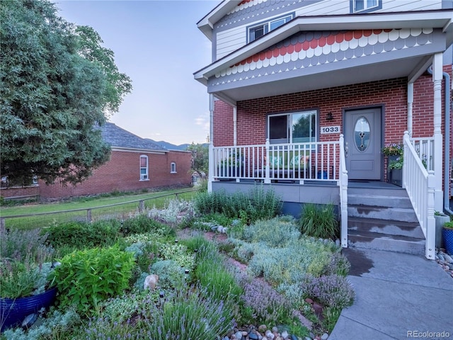 1033 H St, Salida, CO 81201 - view of front of home with brick siding and covered porch