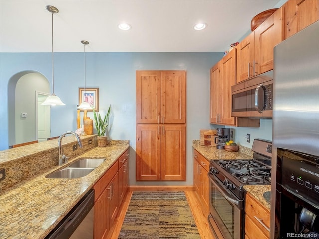 1033 H St, Salida, CO 81201 - kitchen featuring stainless steel appliances, brown cabinetry, light stone counters, pendant lighting, and recessed lighting