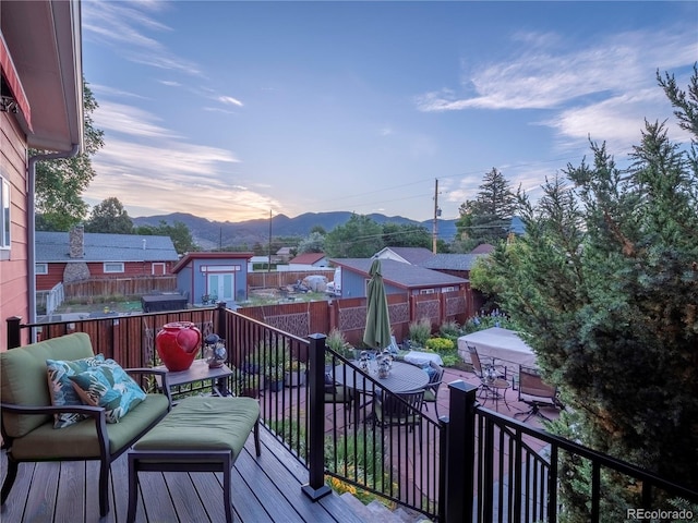 1033 H St, Salida, CO 81201 - deck at dusk with a mountain view, outdoor dining space, and a patio area