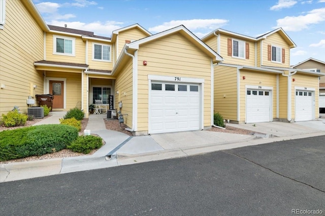 view of front of home with a garage and central AC