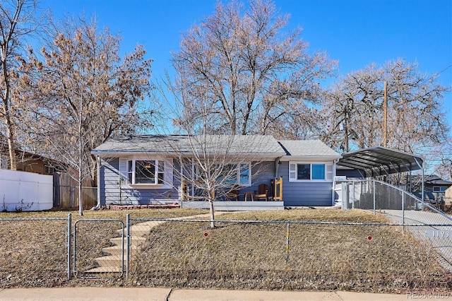 ranch-style house with concrete driveway, a carport, a fenced front yard, and a gate