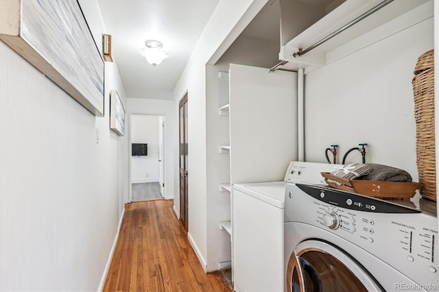 laundry room with light wood-type flooring, laundry area, baseboards, and washing machine and clothes dryer