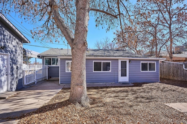 rear view of property featuring fence