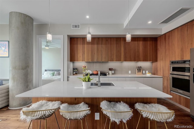 4200 W 17th Ave Unit 625, Denver, CO 80204 - kitchen featuring modern cabinets, stainless steel double oven, brown cabinetry, light countertops, and recessed lighting