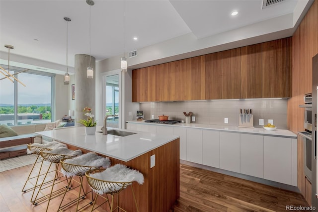 4200 W 17th Ave Unit 625, Denver, CO 80204 - kitchen with modern cabinets, appliances with stainless steel finishes, wood finished floors, backsplash, and light countertops