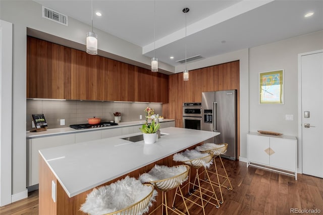 4200 W 17th Ave Unit 625, Denver, CO 80204 - kitchen with stainless steel appliances, modern cabinets, brown cabinets, light countertops, and dark wood-type flooring