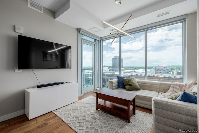 4200 W 17th Ave Unit 625, Denver, CO 80204 - living room featuring healthy amount of natural light, light wood finished floors, and a chandelier