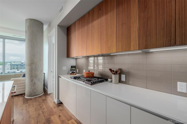 4200 W 17th Ave Unit 625, Denver, CO 80204 - kitchen featuring light countertops, stainless steel gas cooktop, tasteful backsplash, light wood finished floors, and modern cabinets