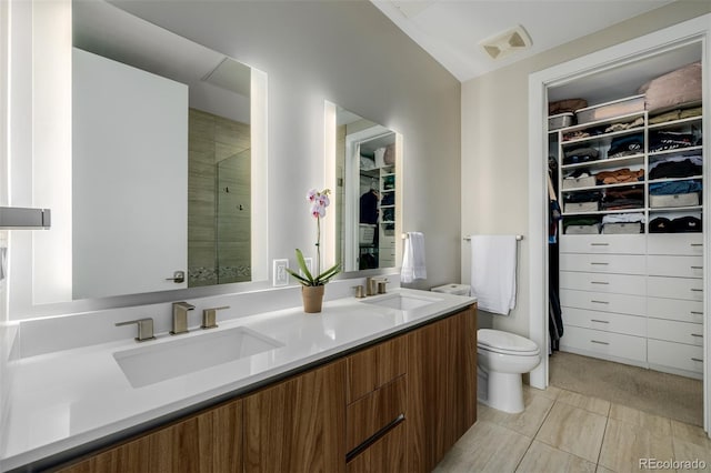 4200 W 17th Ave Unit 625, Denver, CO 80204 - bathroom featuring double vanity, a spacious closet, and a shower stall