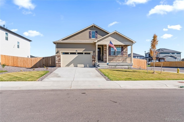 view of front of property with covered porch, fence, stone siding, driveway, and a front yard