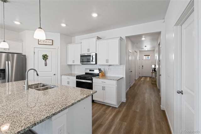 kitchen featuring dark wood-style flooring, tasteful backsplash, appliances with stainless steel finishes, white cabinetry, and a sink