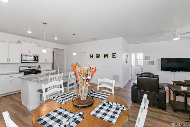 dining room with ceiling fan, visible vents, and wood finished floors