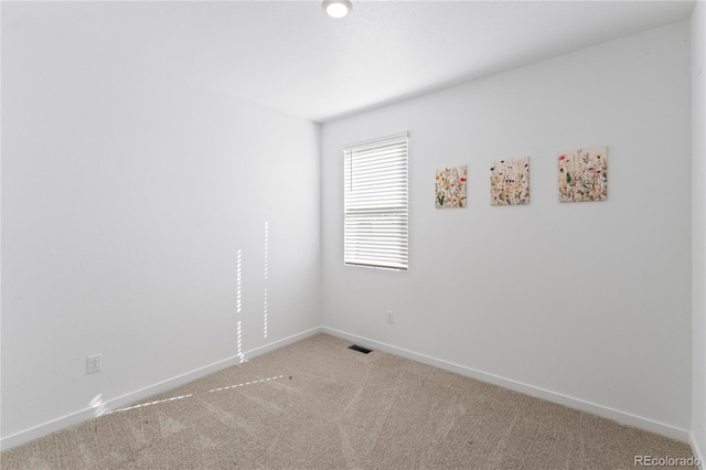 unfurnished room with light carpet, visible vents, and baseboards