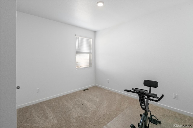 exercise area with visible vents, baseboards, and carpet flooring