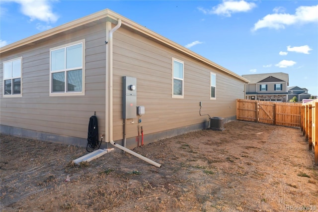 rear view of house with cooling unit and fence