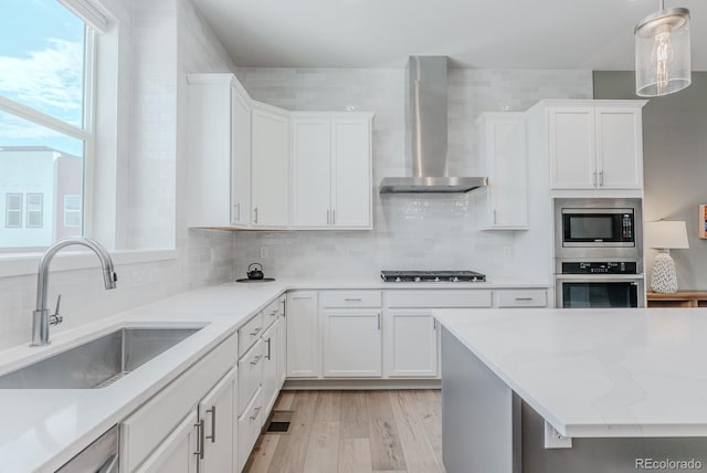 2282 Old Rail Way, Superior, CO 80027 - kitchen featuring appliances with stainless steel finishes, wall chimney range hood, white cabinetry, and tasteful backsplash
