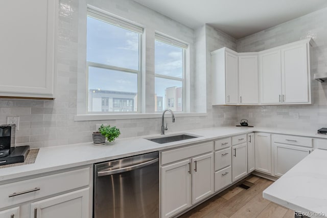 2282 Old Rail Way, Superior, CO 80027 - kitchen with stainless steel dishwasher, white cabinetry, light wood finished floors, and decorative backsplash