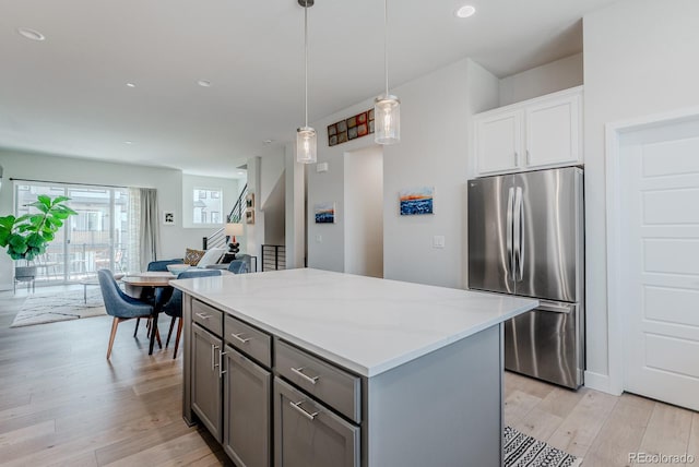 2282 Old Rail Way, Superior, CO 80027 - kitchen featuring freestanding refrigerator, light wood-style flooring, open floor plan, a kitchen island, and gray cabinetry