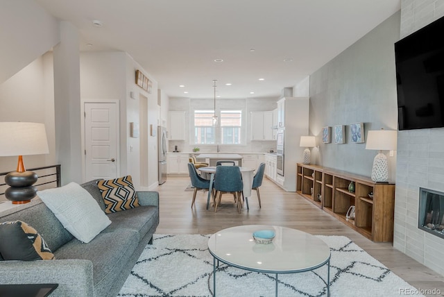 2282 Old Rail Way, Superior, CO 80027 - living room with a glass covered fireplace, light wood finished floors, and recessed lighting
