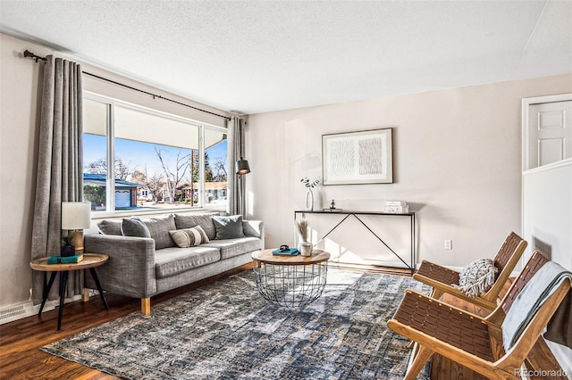 living room featuring wood finished floors, baseboards, and a textured ceiling