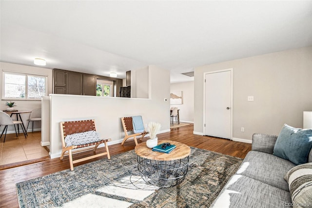 living room with a wealth of natural light, baseboards, and wood finished floors