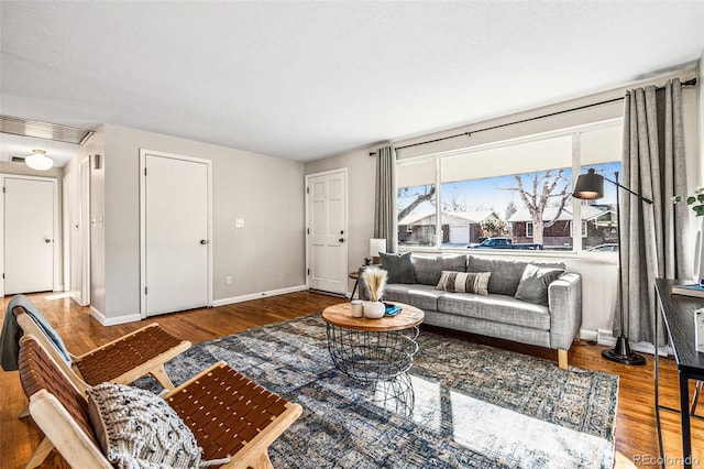 living room with visible vents, baseboards, and wood finished floors