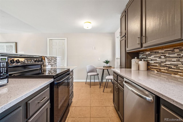 kitchen with light stone counters, tasteful backsplash, stainless steel appliances, light tile patterned floors, and baseboards