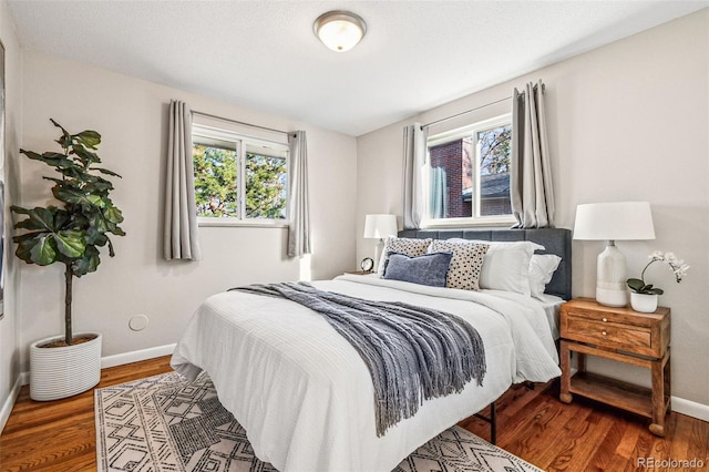 bedroom with wood finished floors and baseboards