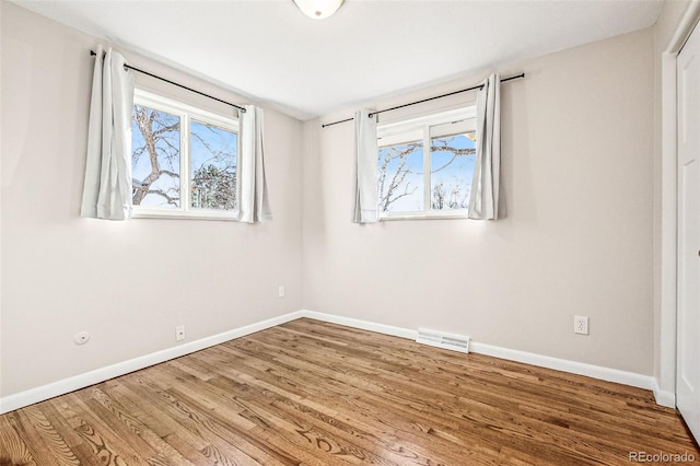 unfurnished bedroom with visible vents, baseboards, and wood finished floors