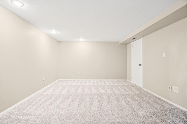 carpeted empty room featuring baseboards