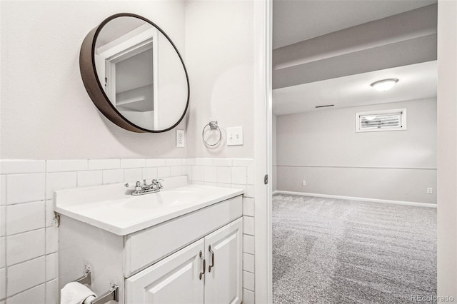 bathroom featuring a wainscoted wall, tile walls, and vanity