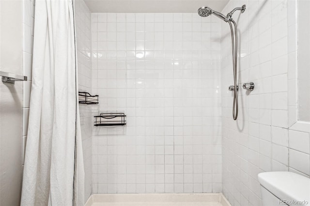 bathroom with a shower stall and toilet