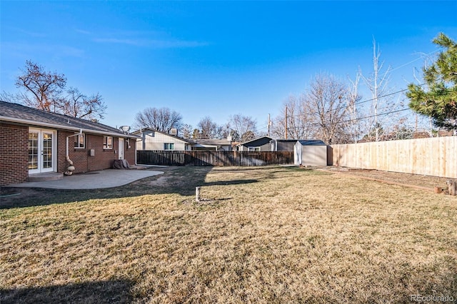 view of yard with a patio, a shed, a fenced backyard, and french doors